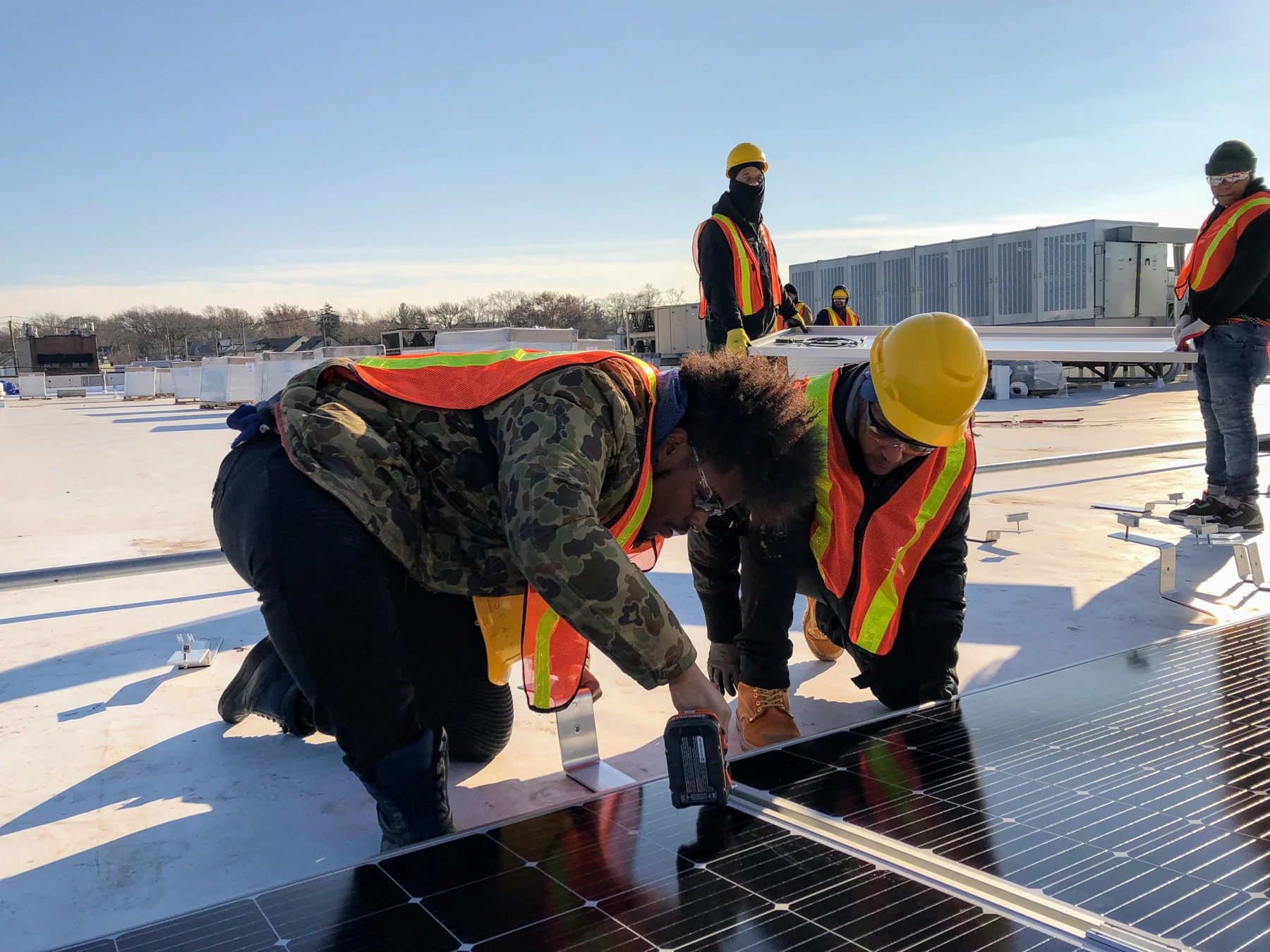 People working together on a solar-panel installation in a supplied photograph from The HOPE Program.